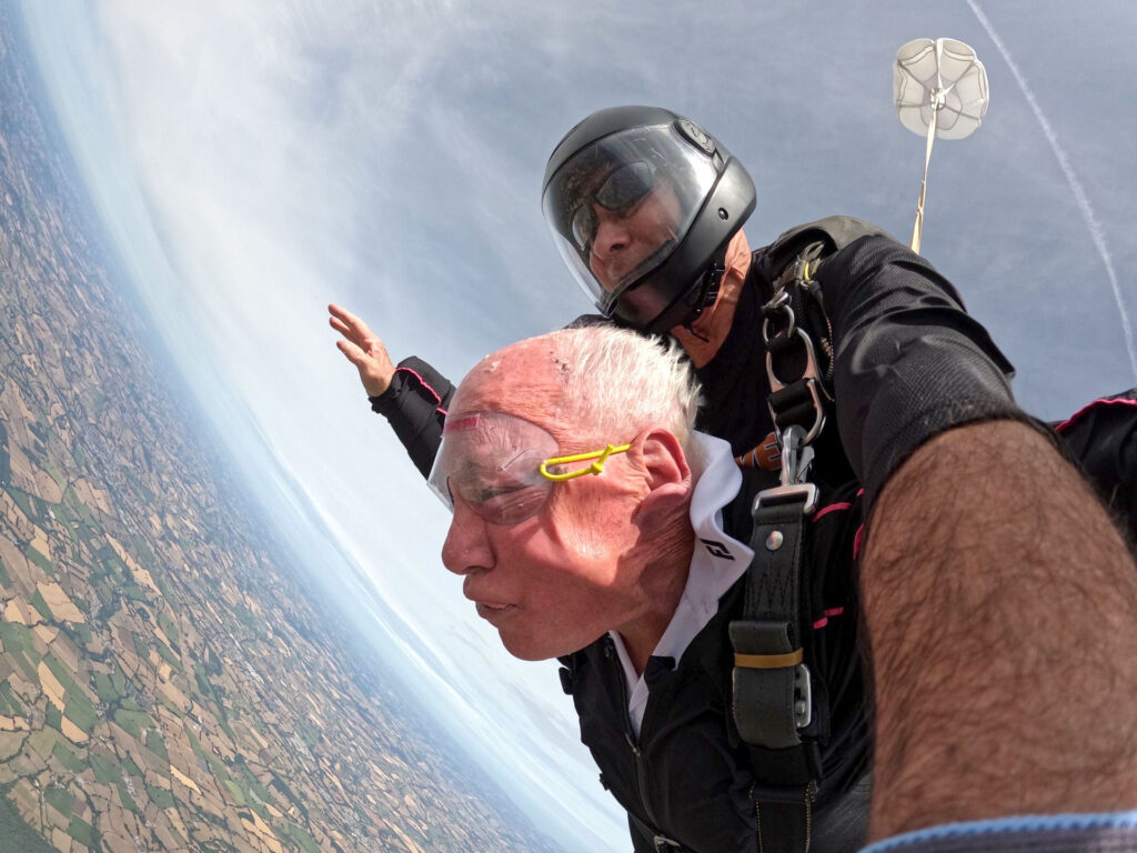 John Payne with his skydiving instructor as free fall above Devon.