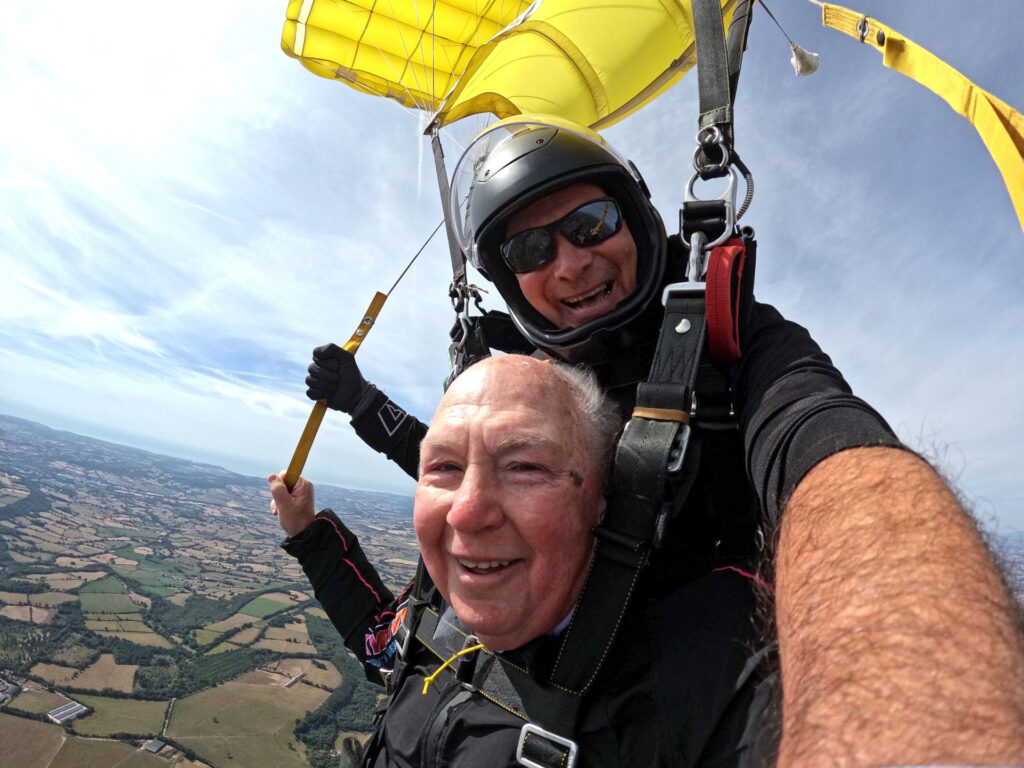 John Payne with his skydiving instructor as they glide back down.